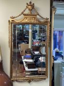Rectangular gilt framed bevelled wall mirror with urn and garland crest, 116cm by 61cm.