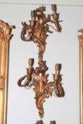 Two pairs of ornate gilt metal wall lights.