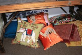 Collection of rugs and scatter cushions.
