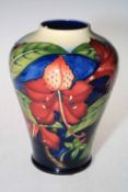 Moorcroft vase decorated with hibiscus design on blue and cream ground, 25cm high.