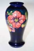 Moorcroft baluster vase decorated with clematis on green ground, 27cm high with box.