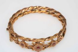 Edwardian 9 carat gold bangle of ornate form and set with three rubies, Chester hallmark 1907.