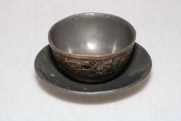 Chinese 19th Century hardwood cup and saucer decorated with Buddhist objects.