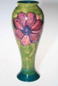 Moorcroft tall vase decorated with anemone on green ground, 28cm high.