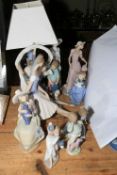 Eleven Nao figurines including table lamp with shade.