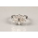 Diamond cluster ring, unmarked white metal set with a vertical baguette cut diamond flanked either