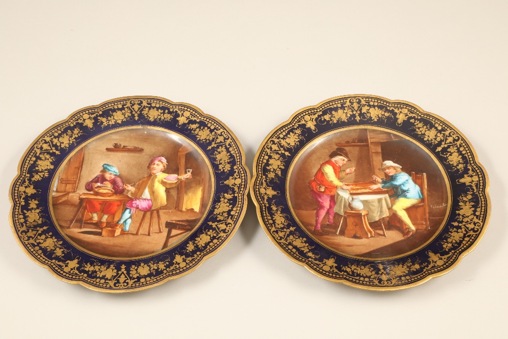 Pair Serves cabinet plates, dark blue ground with hand painted interior scenes with figures,