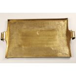 Arts and rafts double handled brass tray, rectangular form with scroll handles, embossed stylised
