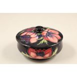 Moorcroft pottery trinket dish and cover, circular form, dark blue ground, decorated with the