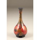 Moorcroft bottle shaped vase, with slender waisted neck and flared rim, in the pomegranate