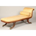 Regency mahogany scroll end chaise longue, raised on outswept reeded legs, terminating in castors.