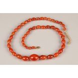 Amber necklace of graduated oval beads, largest 27mm long, necklace 62cm long Total weight 87g