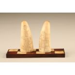 Pair scrimshaw mounted to a chequer board, decorated with children playing, teeth measure 10cm High