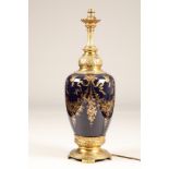 Large porcelain table lamp, gilt metal base and neck, decorated with gilt floral swags and tails