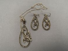 A silver marcasite pendant on chain together with matching earrings