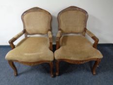 A pair of beech framed French style salon armchairs upholstered in a gold fabric