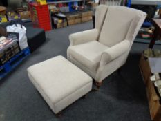 A Marks & Spencers wingback armchair with footstool upholstered in a beige fabric