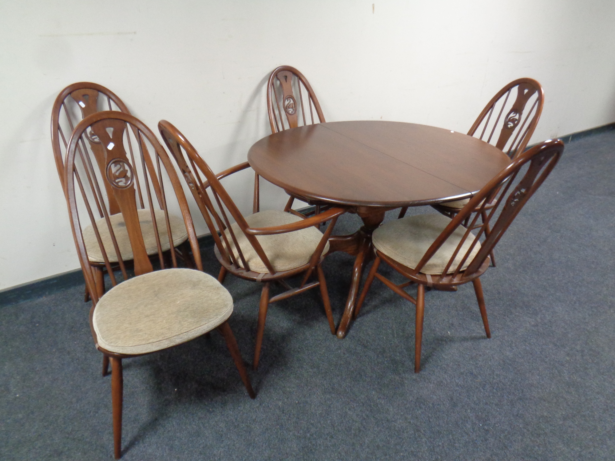An oval Ercol pedestal extending dining table fitted a leaf together with a set of six Windsor swan