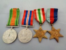 Four World War II medals on ribbons to include The War Medal, The Defence Medal,
