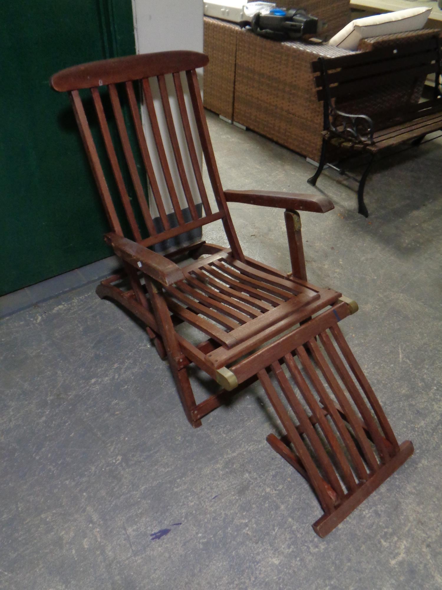 A teak steamer garden armchair with foot rest