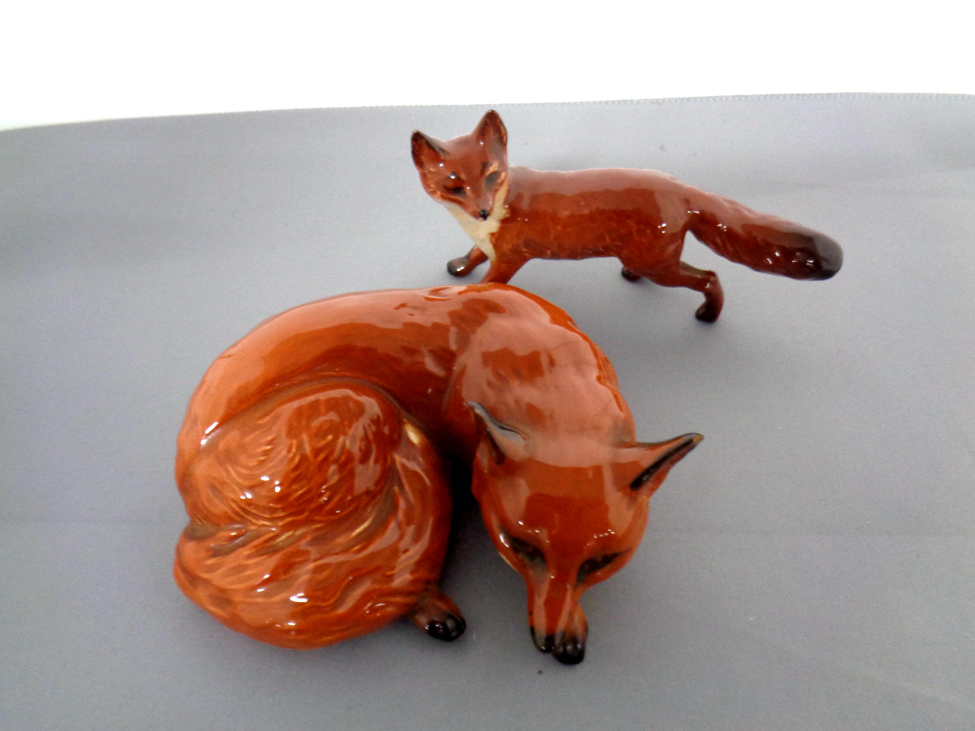 Two Beswick figures, fox curled No. 2017 and fox standing No.