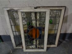 Three antique stained leaded glass windows in frames