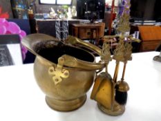 An antique brass swing handled coal bucket and a three piece brass Mayflower companion set on stand