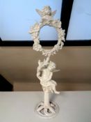 An antique painted cast iron cherub on plinth holding photo frame