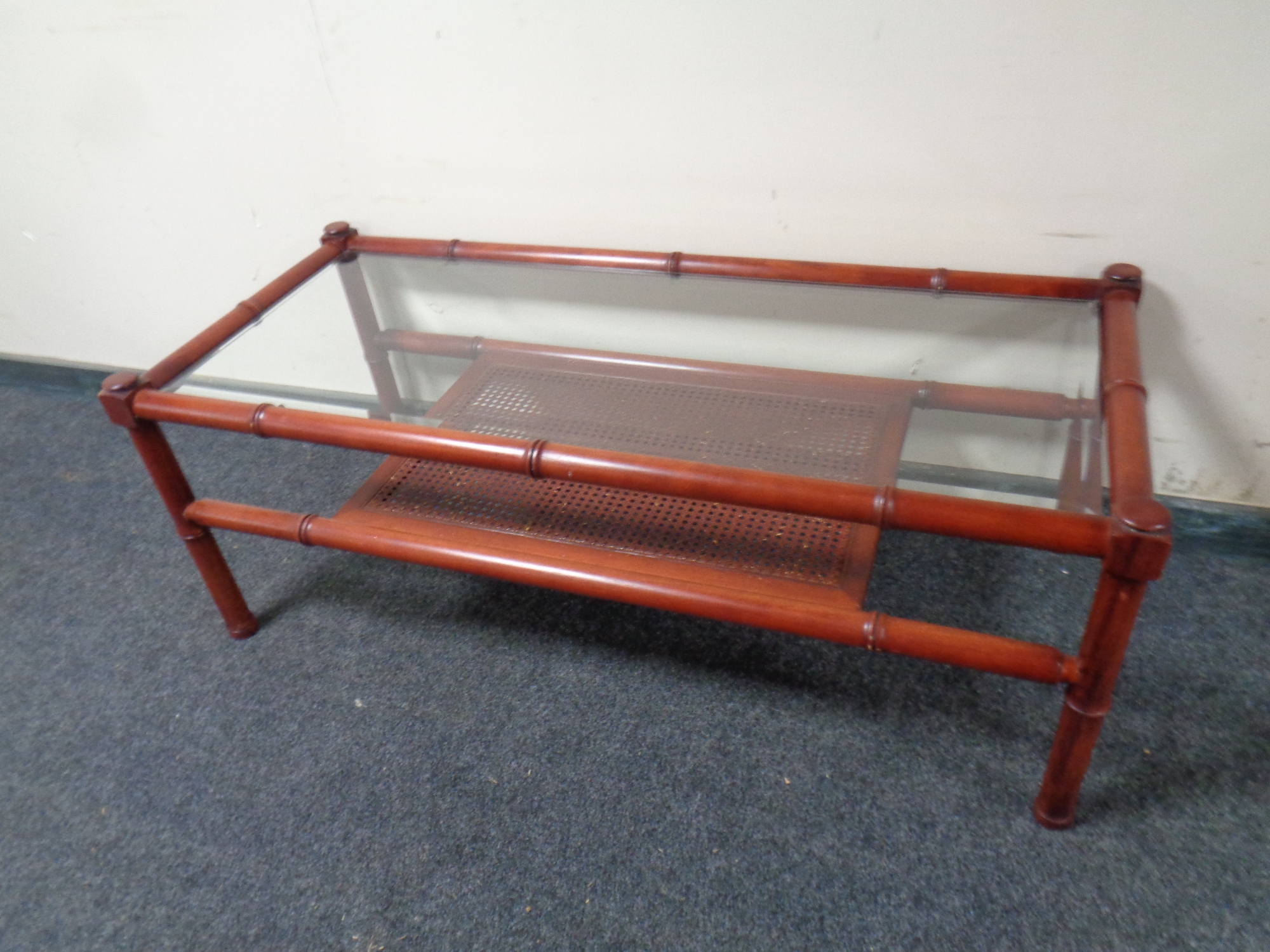 A bamboo and wicker glass topped conservatory coffee table with under shelf