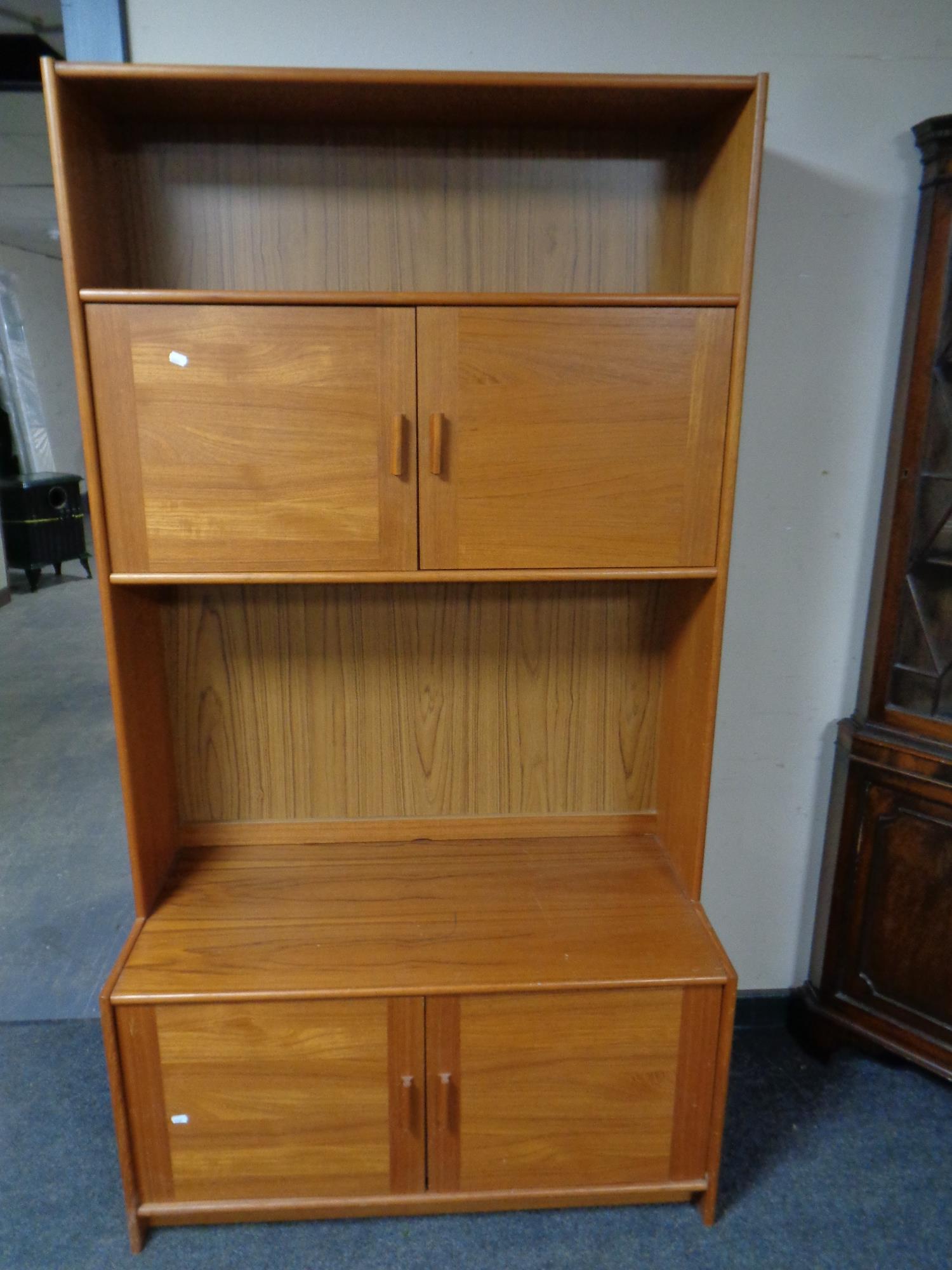 A 20th century teak effect bookcase fitted cupboards