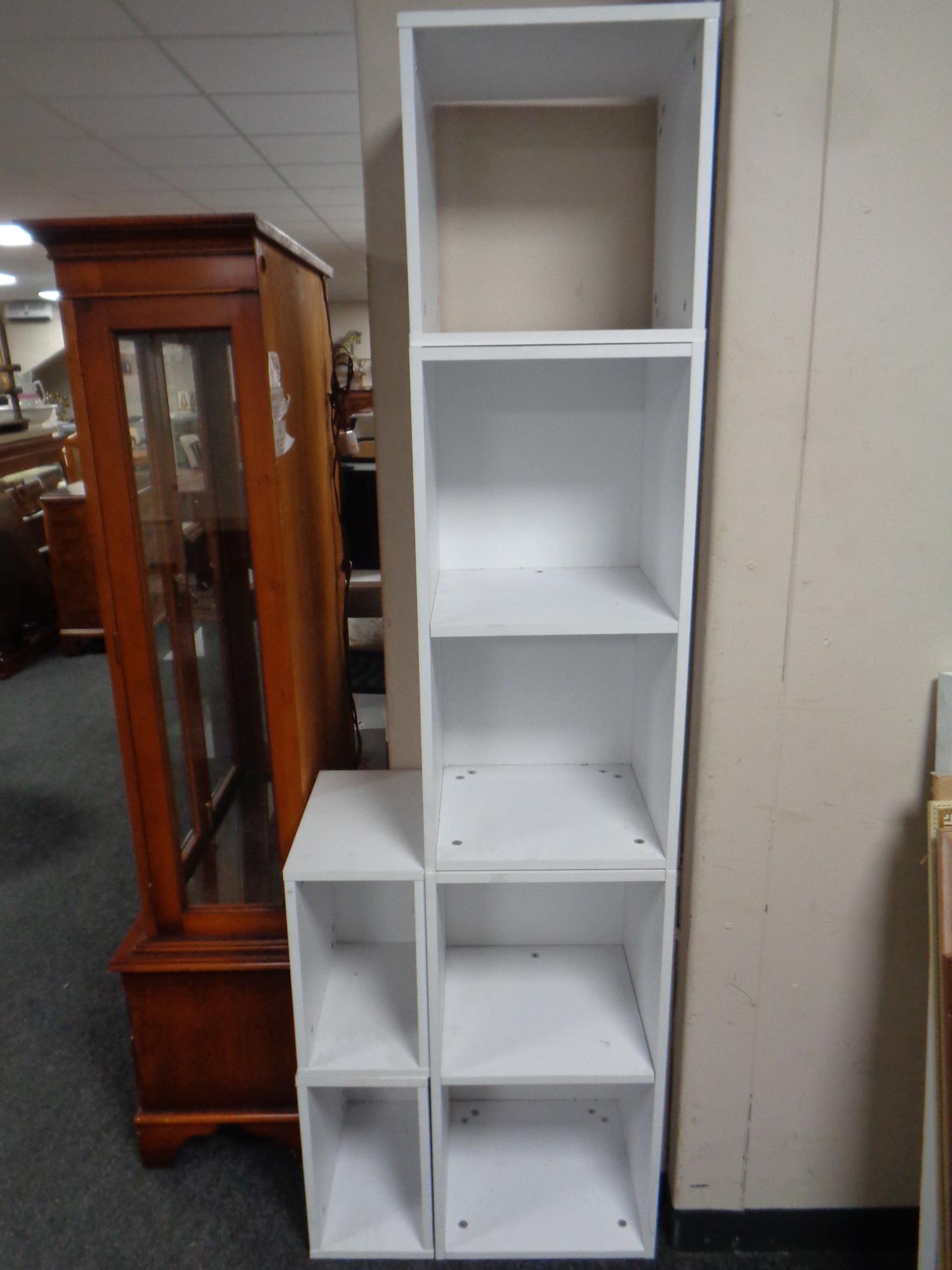 Five white modular record storage shelves