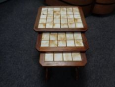 A nest of three 20th century teak tile topped tables