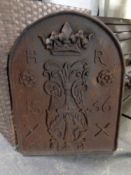 A cast iron embossed fire back initialled HR and bearing date 1536