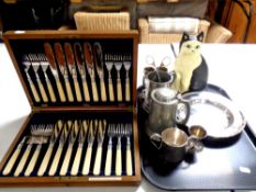 An Edwardian oak canteen of fish cutlery together with a tray containing cast iron cat doorstop and