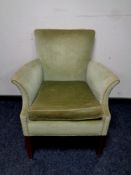 A mid 20th century fire side armchair upholstered in a green dralon