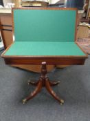 A Victorian style mahogany turnover top pedestal card table on brass capped feet