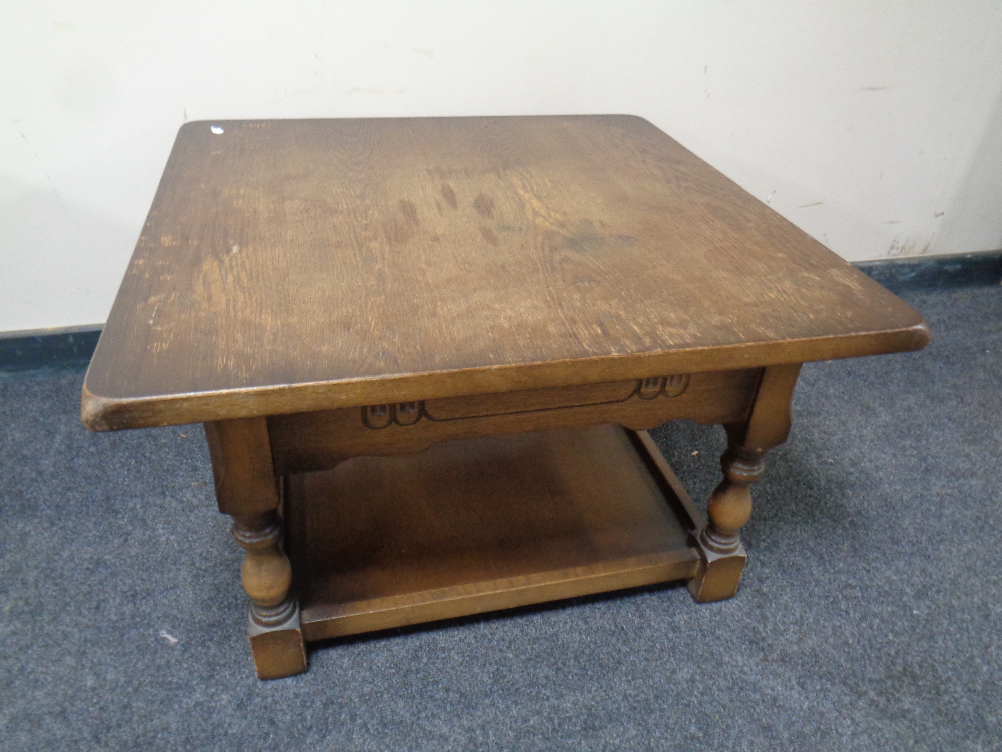 A square two tier coffee table in an oak finish