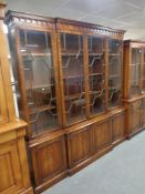 A reproduction mahogany Regency style four door break front bookcase fitted cupboards beneath