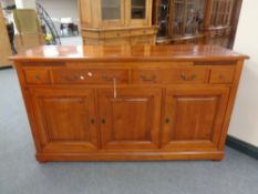 A Barker and Stonehouse triple door sideboard fitted four drawers