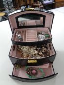 A faux leather jewellery box containing a quantity of costume jewellery to include brooches, rings,