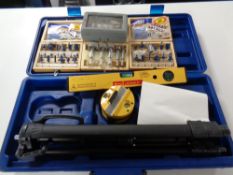 A cased laser level and assorted cased router bits