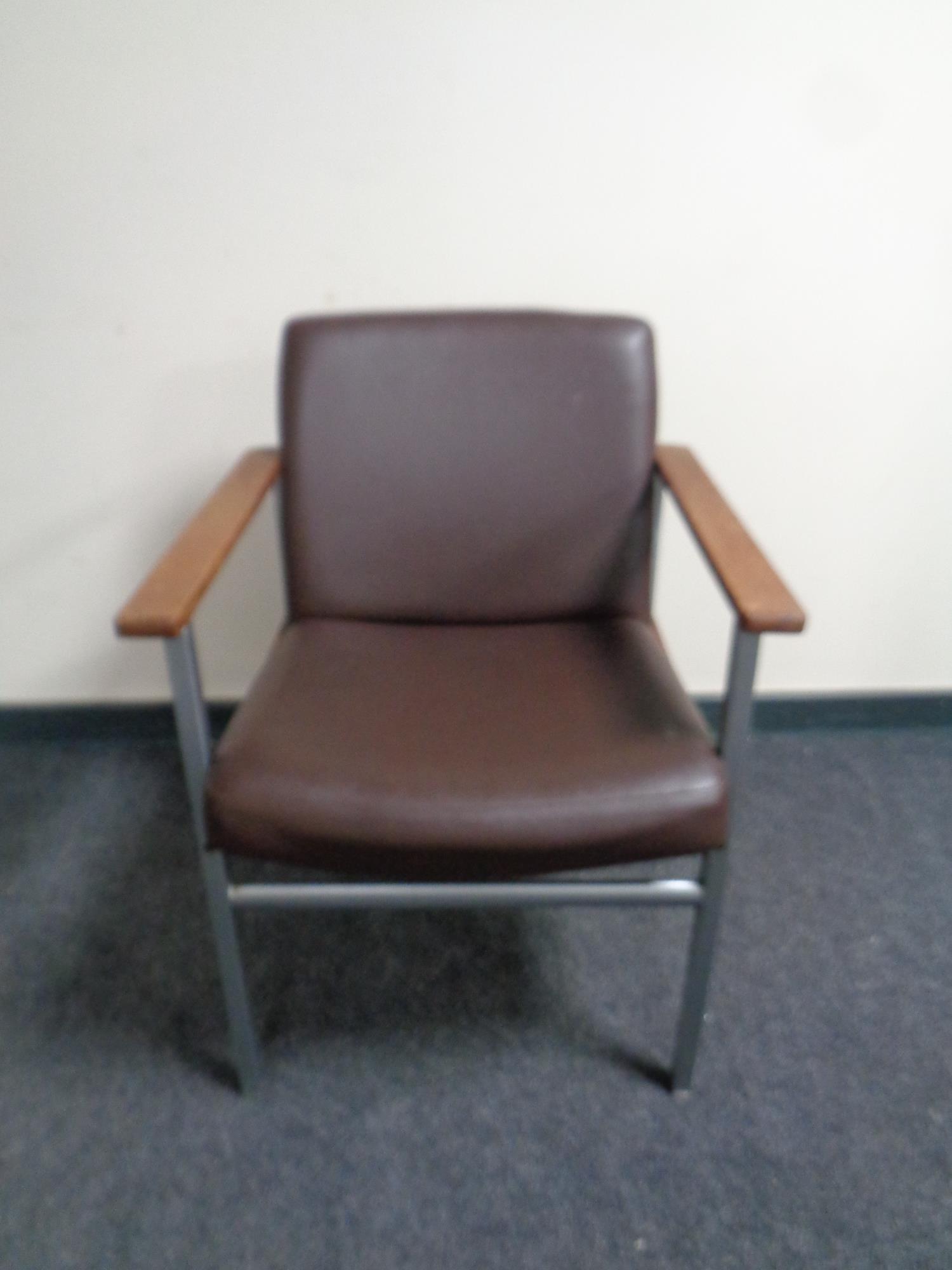 A 20th century metal framed teak armed brown vinyl upholstered armchair