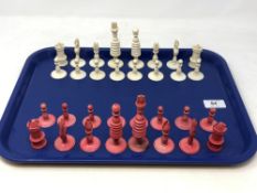 A turned and stained ivory chess set, circa 1900, Kings 9.5cm.