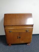 A mid 20th century oak bureau fitted double door cupboard