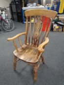 An antique pine kitchen armchair