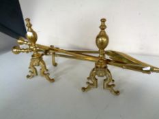 A pair of 19th century brass fire dogs together with three brass companion pieces