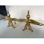 A pair of 19th century brass fire dogs together with three brass companion pieces