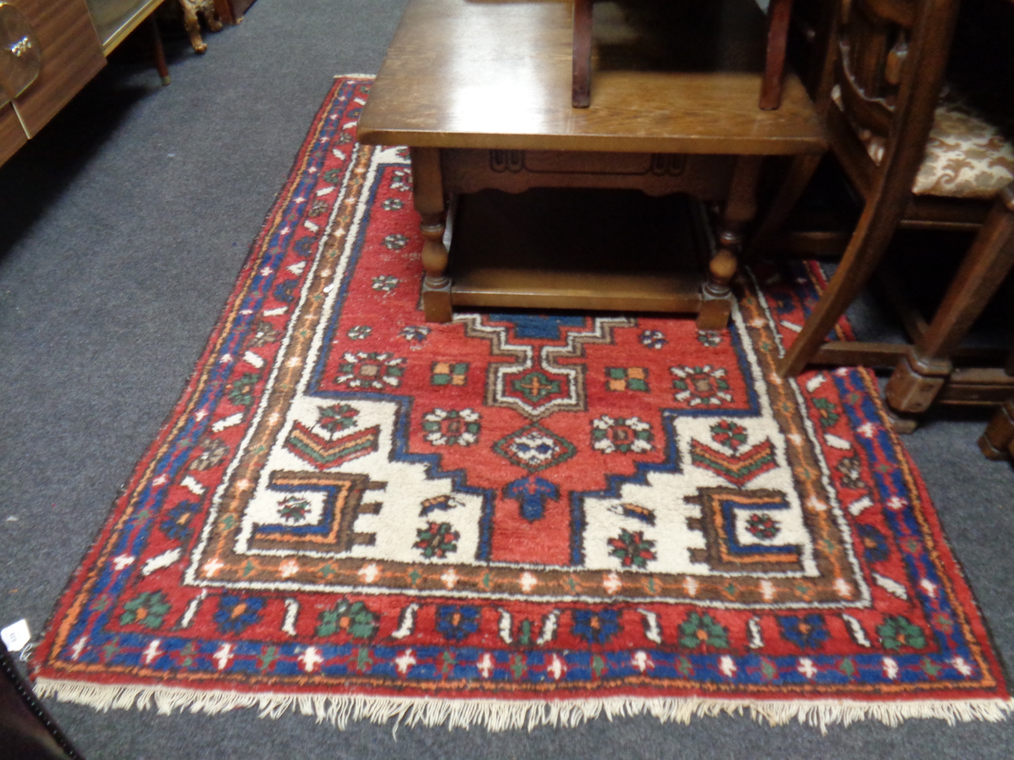 A fringed Persian rug of geometric design