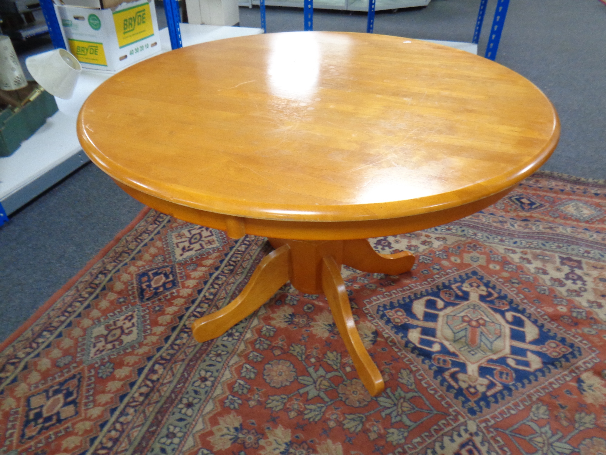 A circular pine pedestal kitchen table