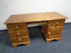 A contemporary pine twin pedestal desk